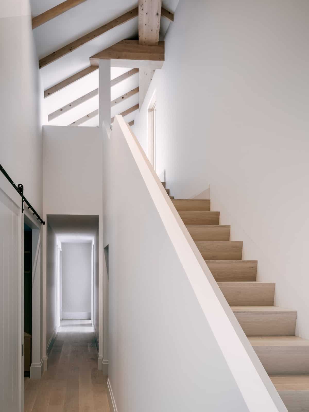 Stair hallway with white walls and a hardwood floor.