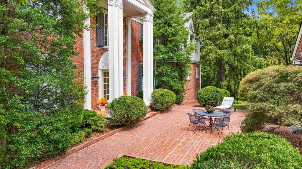 The rear entrance into the house was created to reflect the style of the double portico on the front. This is also a grand entrance. Lush mature landscaping in abundance and expansive brick patios allow for entering outdoors in grand style.
