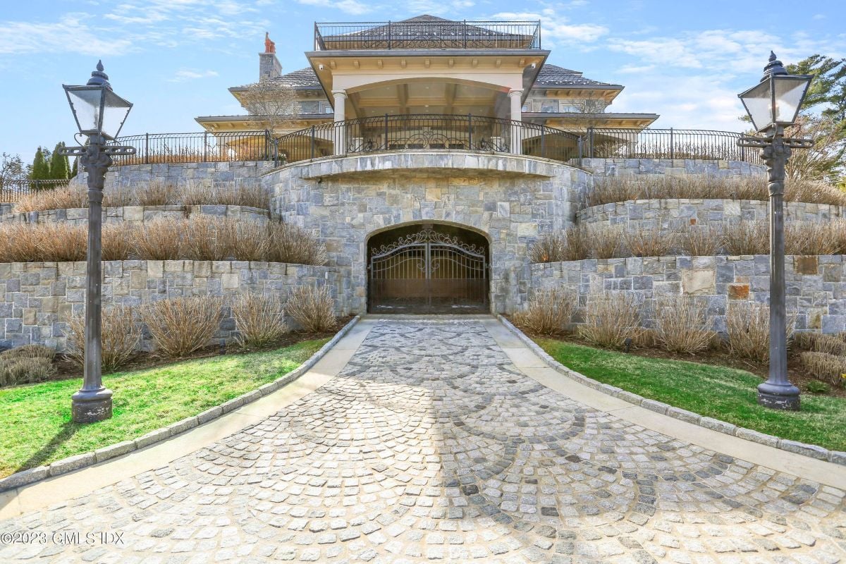 The imposing mansion was surrounded by a sturdy brick wall and a gleaming metal gate, adding an extra layer of security to its grandeur.