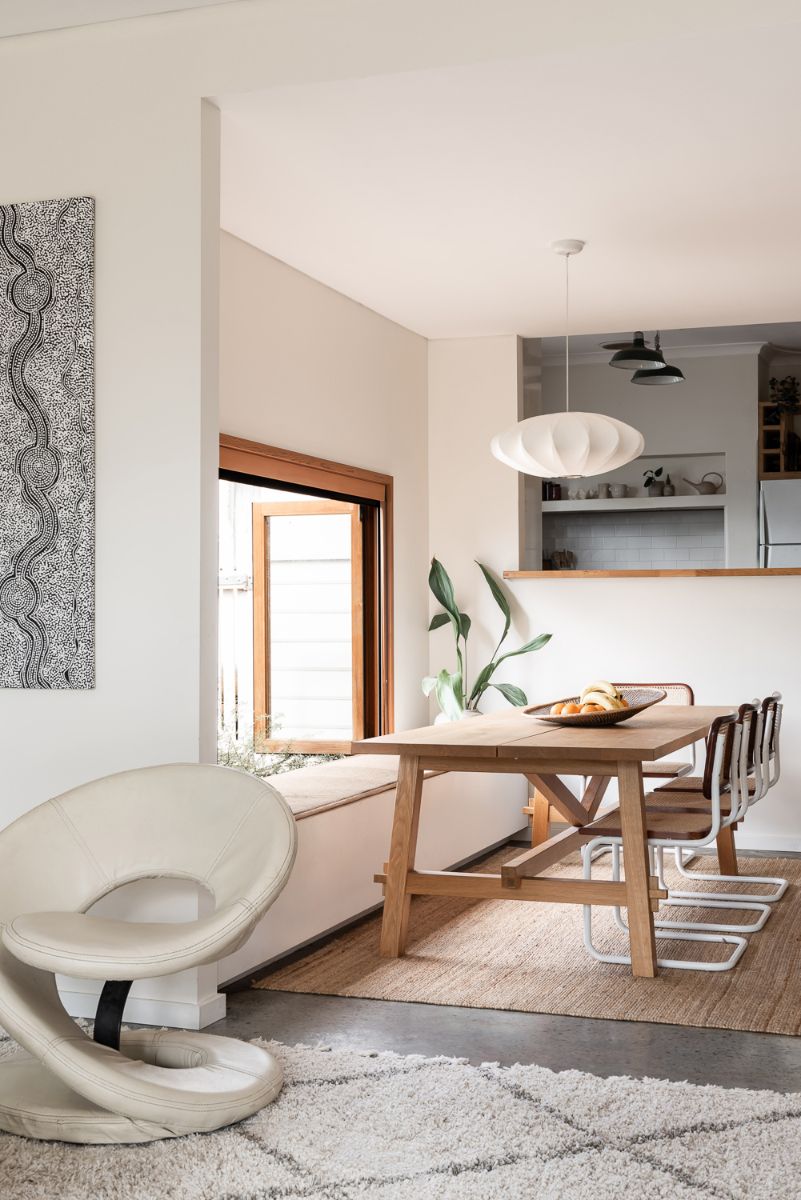 The dining area with cedar bi-fold windows open outwards above an in-built banquette seat, forming a perfect nook to read the paper with the morning eastern light coming through.