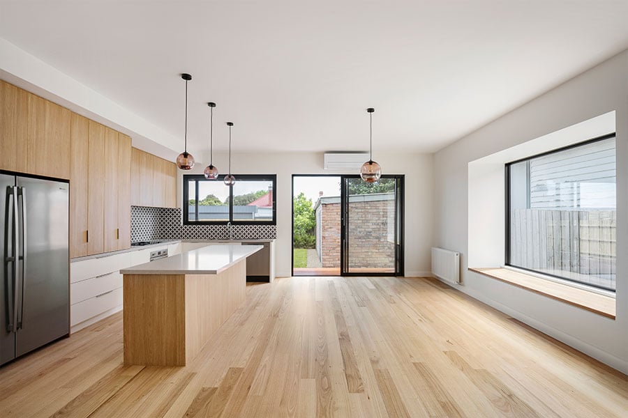 An open-concept kitchen, living, and dining area with direct access to the backyard.