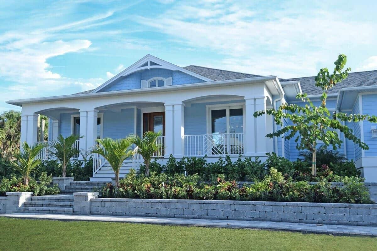 Front exterior view showcasing the covered entry porch adorned with archways, double columns, and a recessed shingle-style dormer on top.