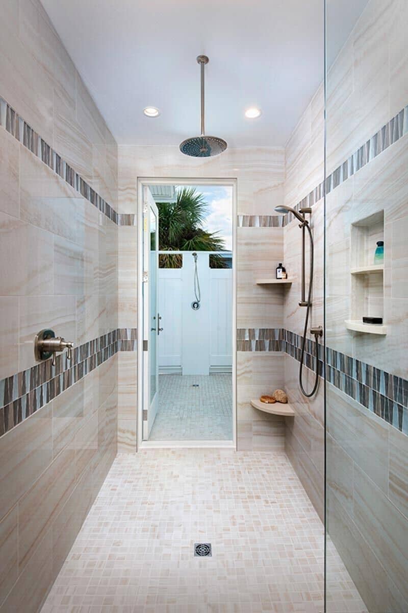 The primary walk-in shower extends to the outdoor shower through a glazed door.