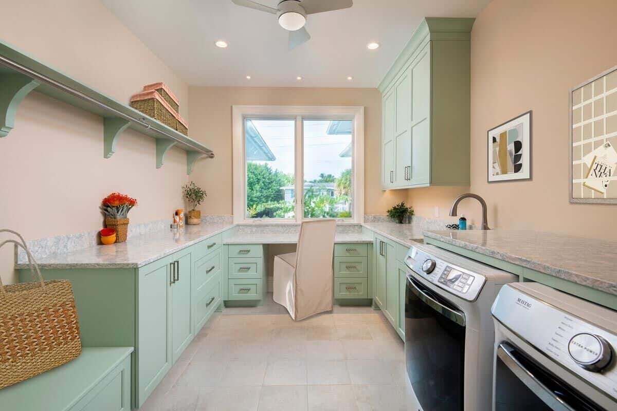 The laundry room offers plenty of storage, counter space, and a built-in desk.