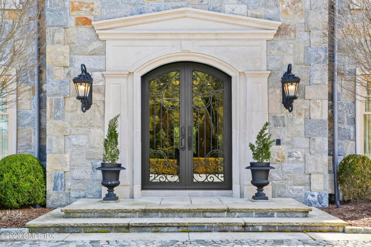 The entrance to the estate was marked by a towering metal gate, which was accentuated by the soft glow of wall lights, creating an aura of grandeur and elegance.