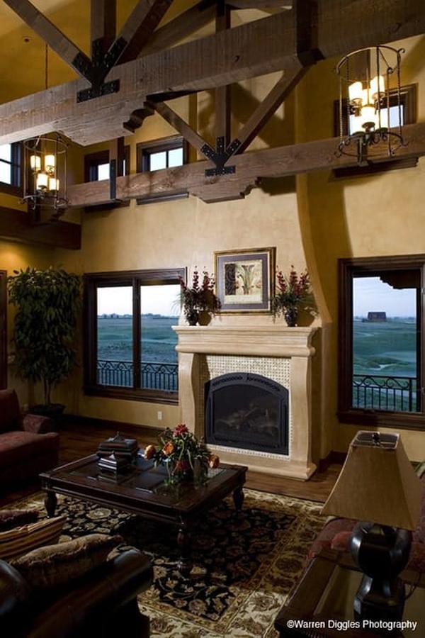 Hearth room with cozy seats, a glass top coffee table, and a fireplace adorned with flower vases and a framed artwork.