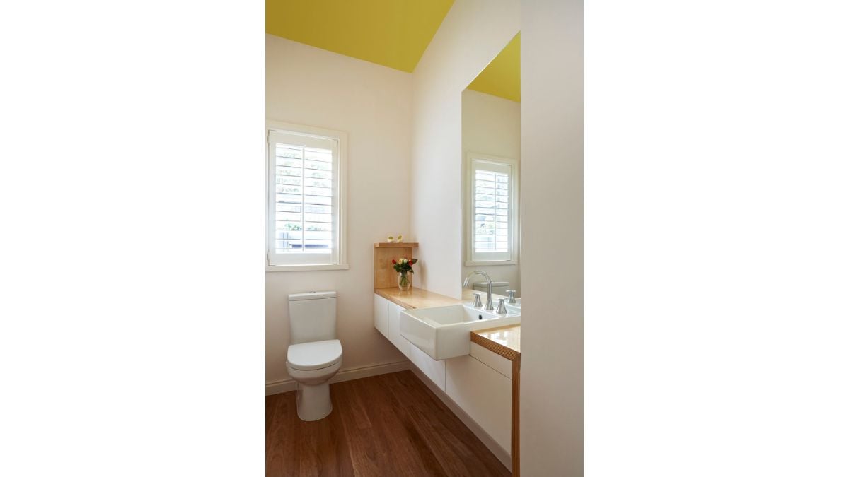 The wooden floors in this bathroom go nicely with the aesthetically pleasing colors.
