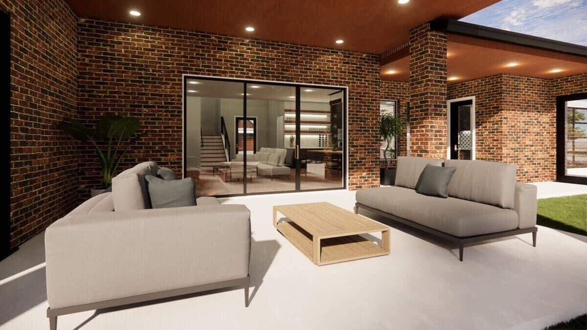 Covered porch with modern sofas and a wooden coffee table over concrete flooring.