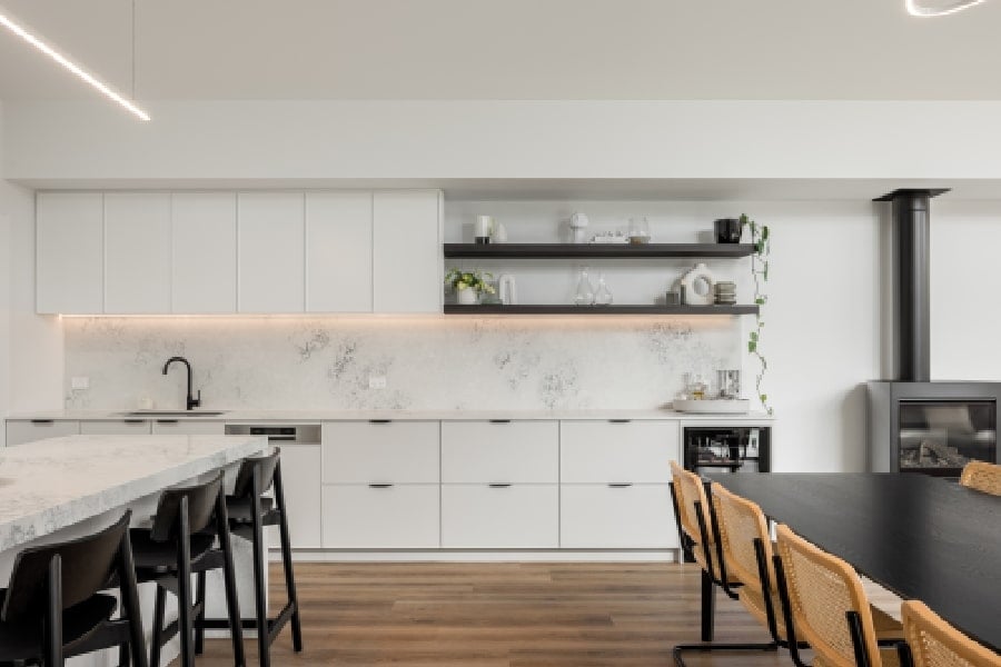 A modern white kitchen adjacent to the dining area.