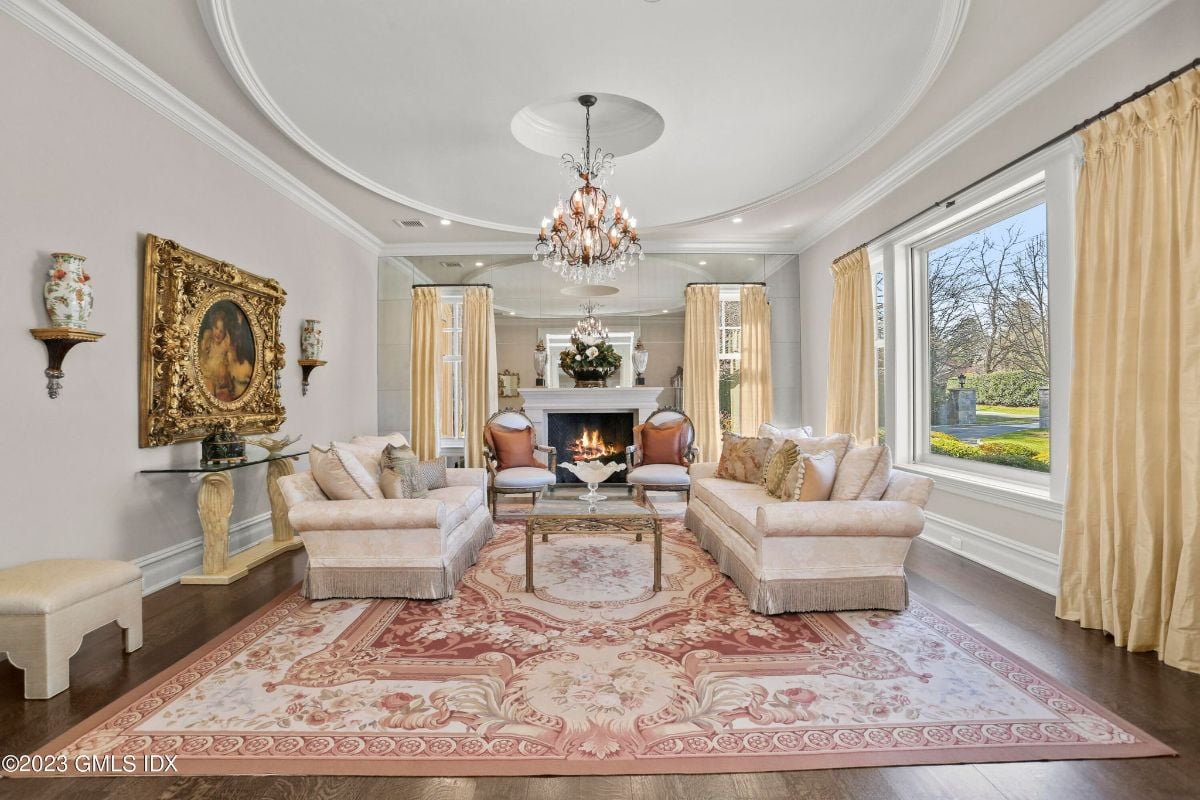 Stepping into the grand foyer of the mansion, I was greeted by a magnificent stair case that ascended towards a mesmerizing chandelier, illuminating the entire area with its dazzling light.