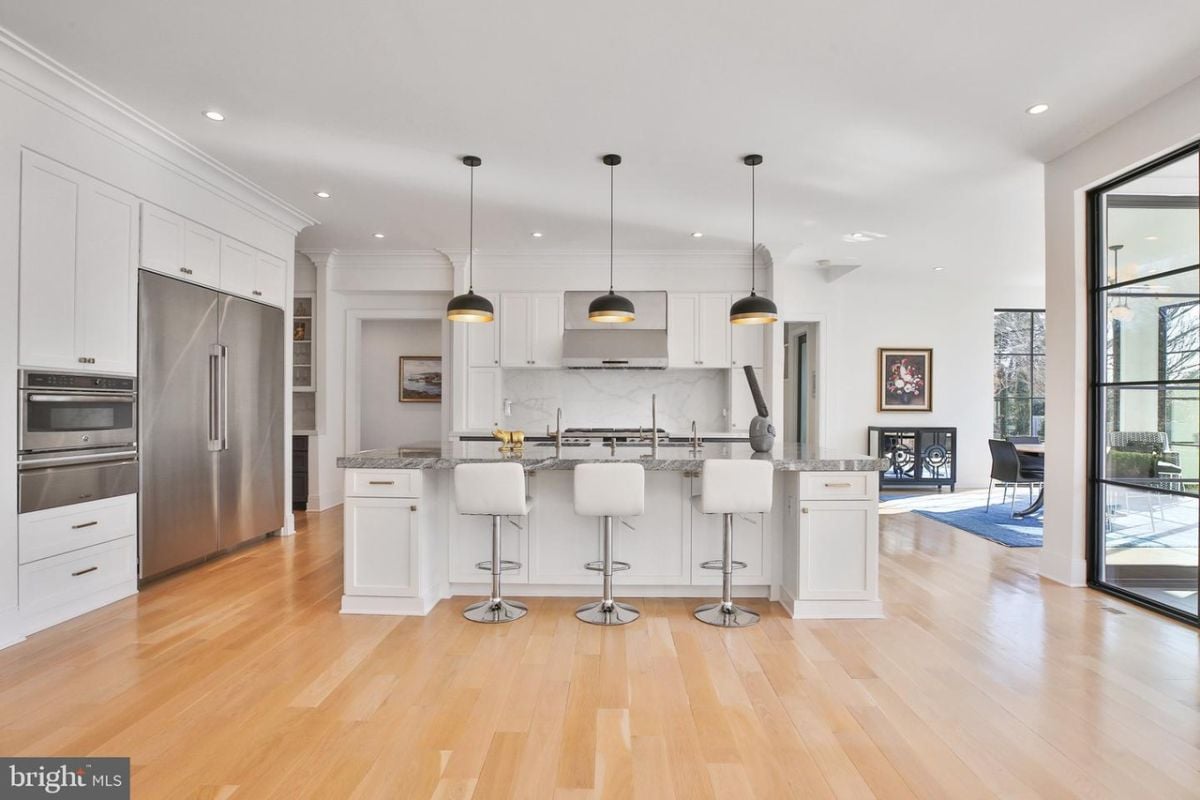 The spacious kitchen boasted a beautiful island that served as a centerpiece, illuminated by a stylish pendant light that added a touch of modern elegance to the room.