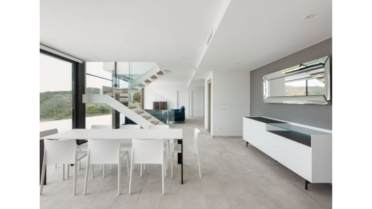 Everything in the dining area is completely white, including the table, seats, and shelves.