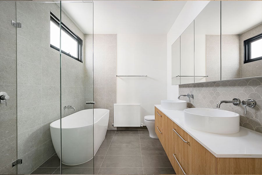 The bathroom, which includes a separate toilet, a round counter-topped sink, and a free-standing tub.