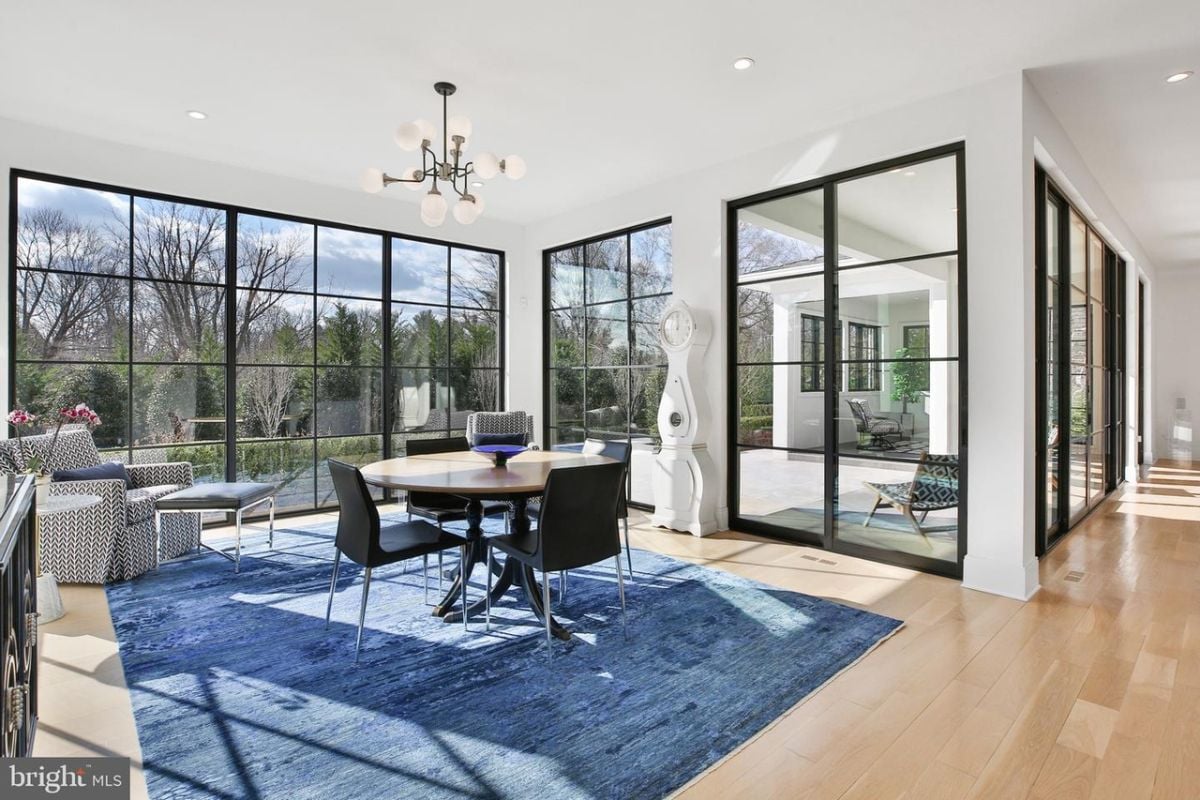 In the cozy dinette, a round table sat beneath the sunlight streaming in through the large glass windows, creating a warm and inviting atmosphere for morning coffee and breakfast.
