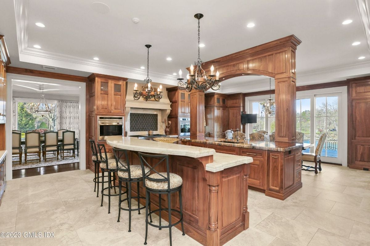 In the kitchen, the sleek kitchen counter was illuminated by a stunning chandelier, lending a touch of opulence to the practical space and making meal preparation feel like a luxurious affair.