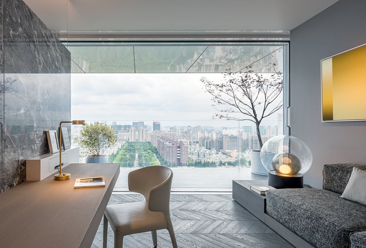 Merely separated from the living area by ceiling-high glass, there is a small, half-open workspace with a comfortable sofa corner. 