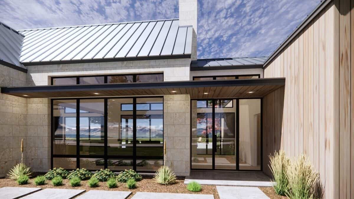A closer look at the covered entry porch with a glazed front door flanked by floor-to-ceiling windows.