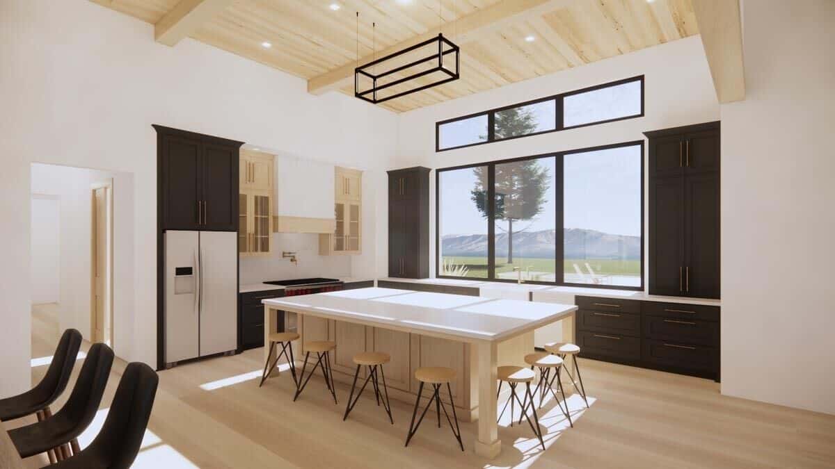 The kitchen has dark cabinetry, a center island, a beamed ceiling, and clerestory windows bringing ample natural light in.
