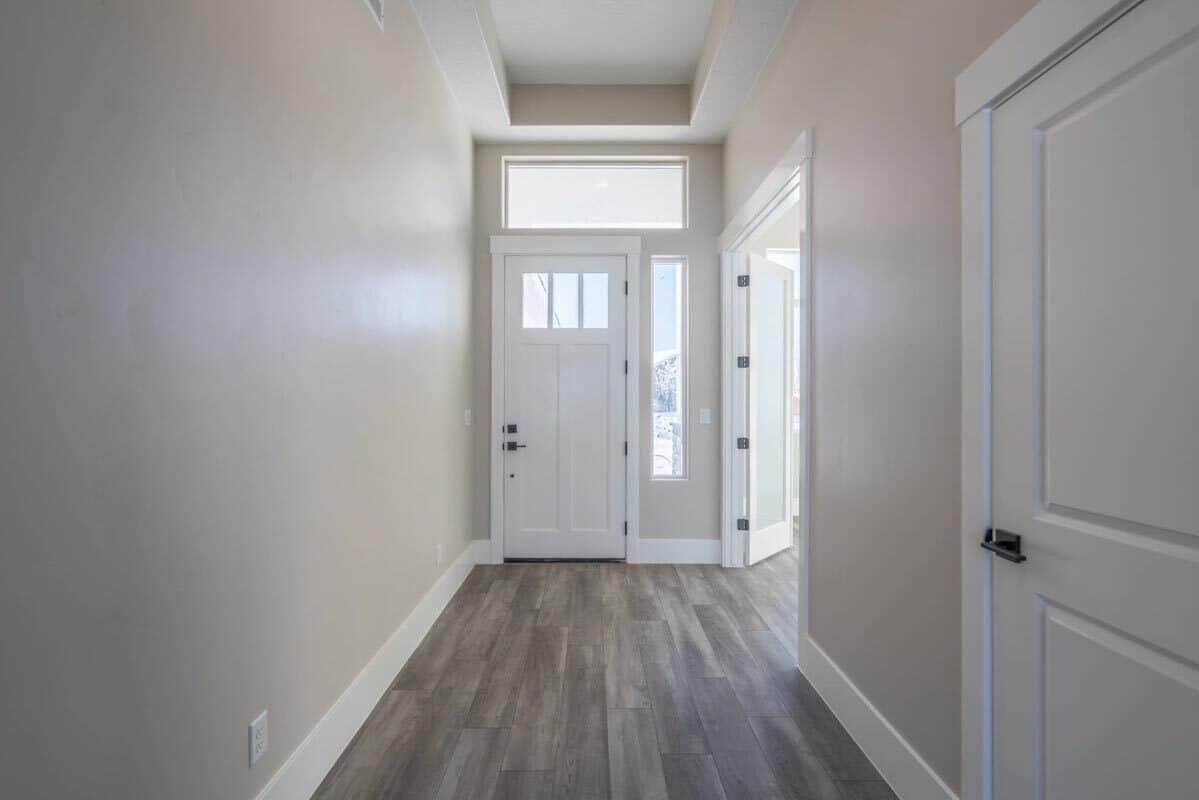 Foyer with a glazed entry door and a tray ceiling.