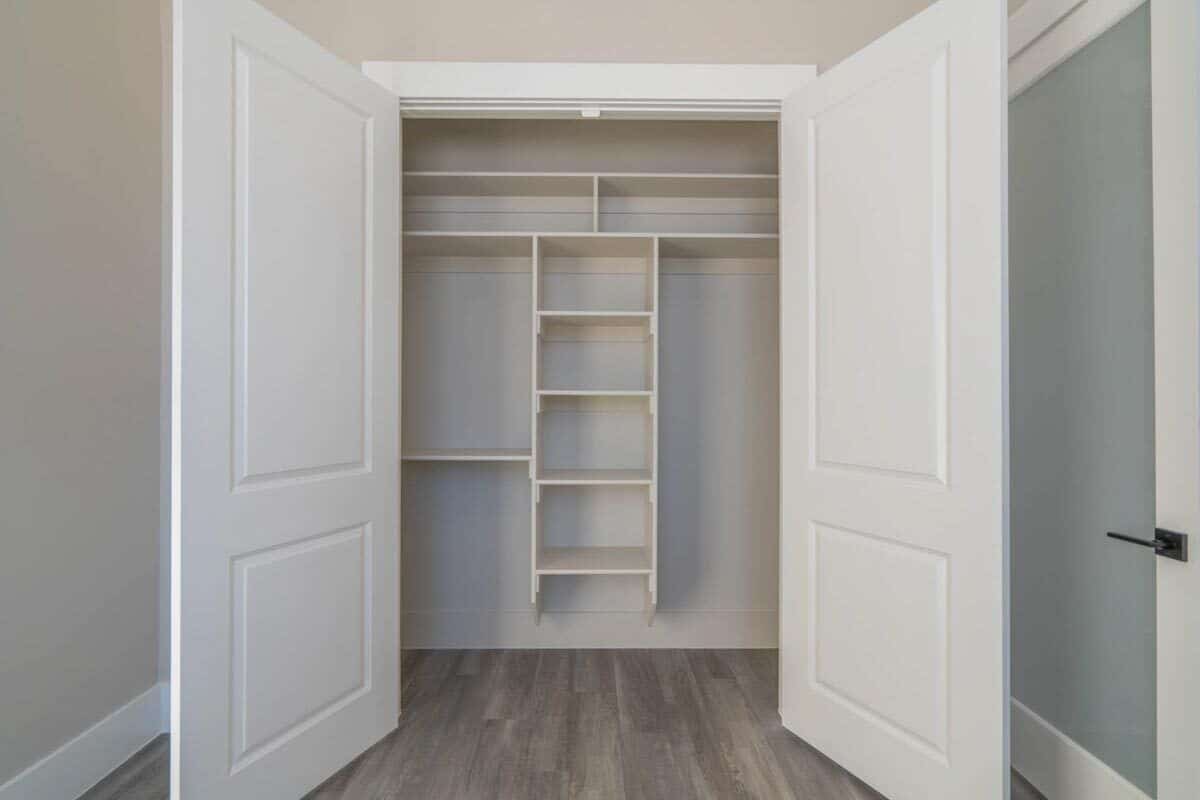 The bedroom features a built-in closet enclosed in white double doors.