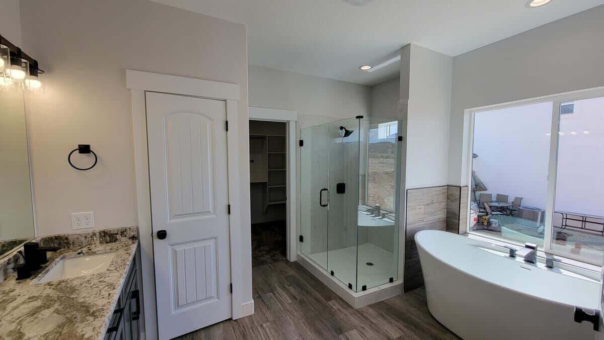 A walk-in closet, tiled shower, and freestanding tub complete the primary bathroom.