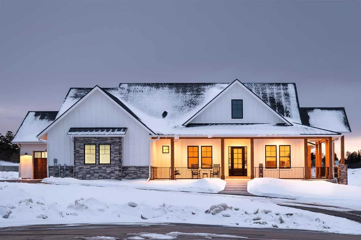 Front exterior view with a side garage and a wraparound porch bordered with timber posts.