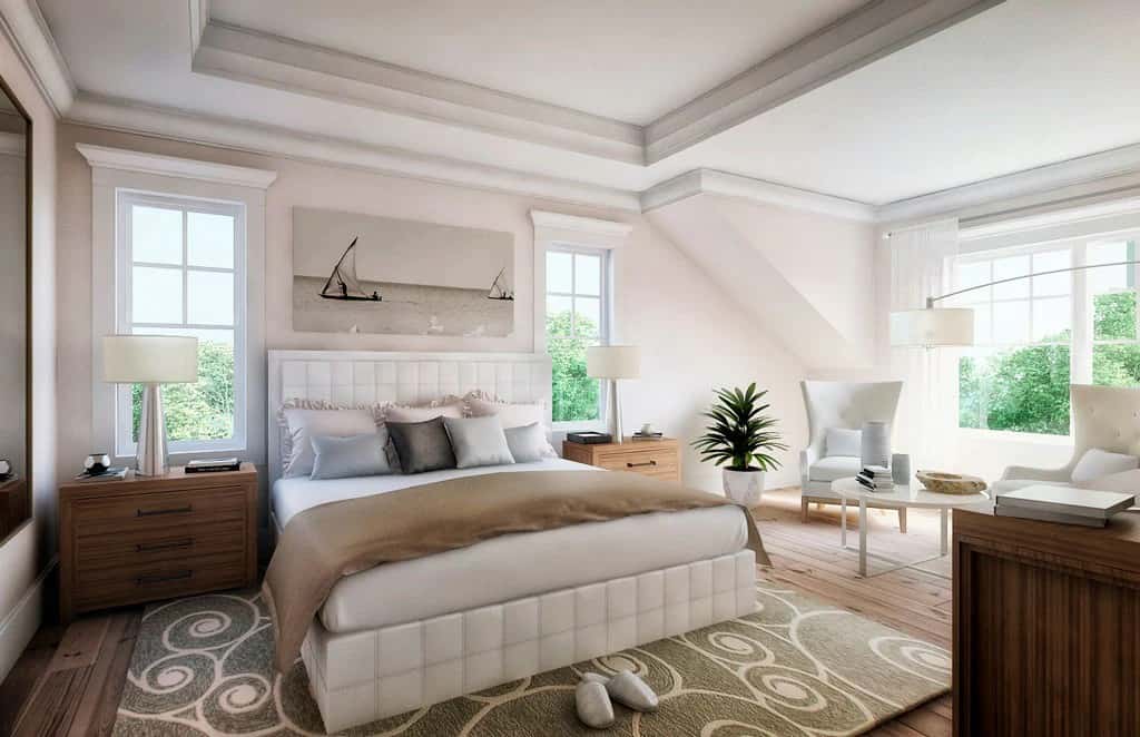 The primary bedroom features a tray ceiling and a seating area with wingback chairs.