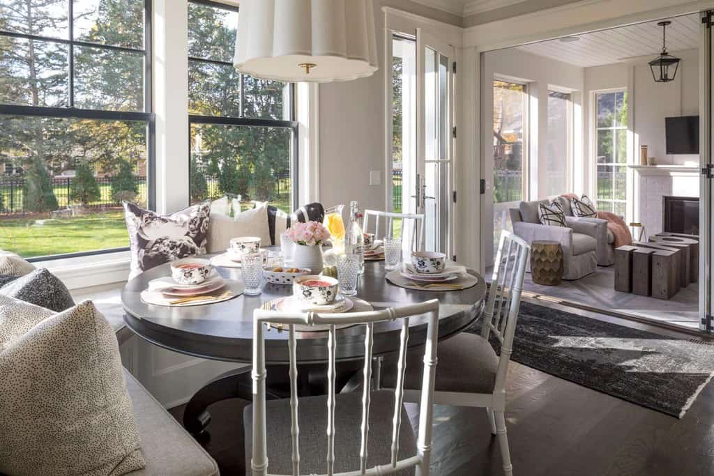 The breakfast nook has a round dining set and easy access to the screened porch through folding glass doors.