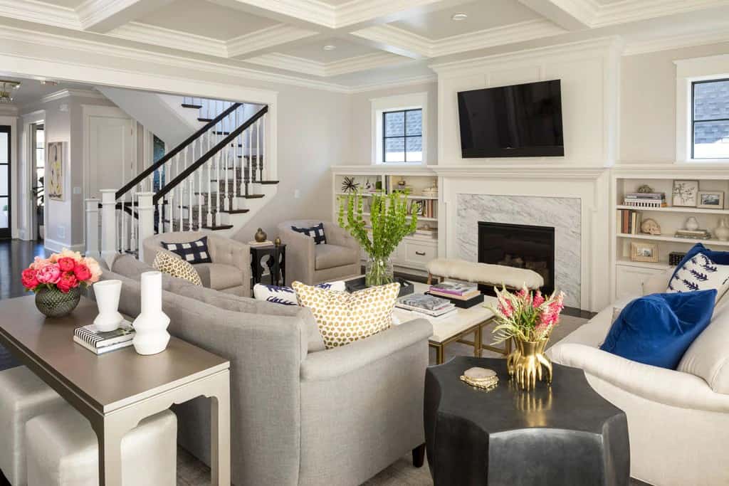 The great room offers comfy seats, a wall-mounted TV, and a fireplace flanked by white built-ins.