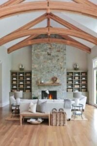 This is a giant space featuring gorgeous exposed wooden vaulted ceilings, an even more stunning stone fireplace, and wall to wall windows to let that natural light in.