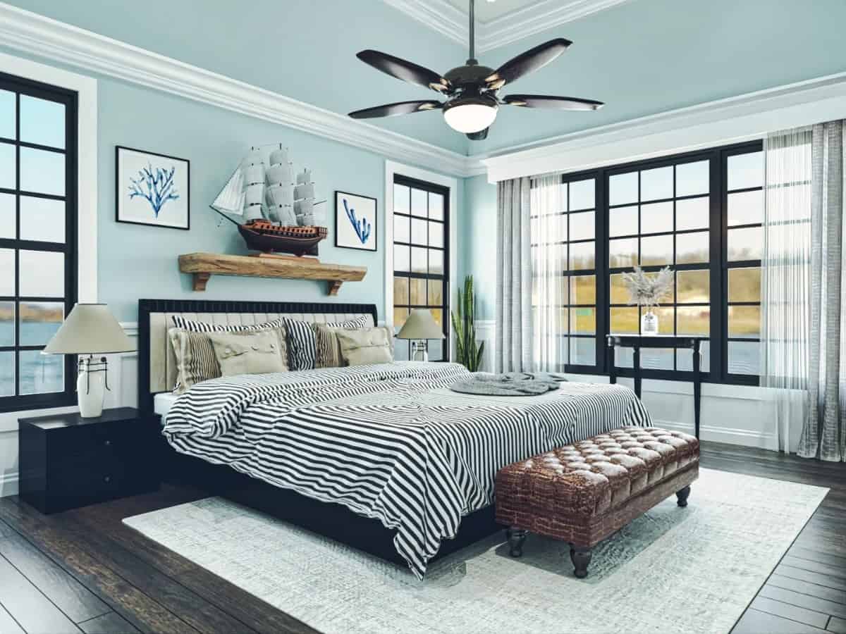 The primary bedroom has light blue walls and a dark hardwood floor topped with a distressed area rug.