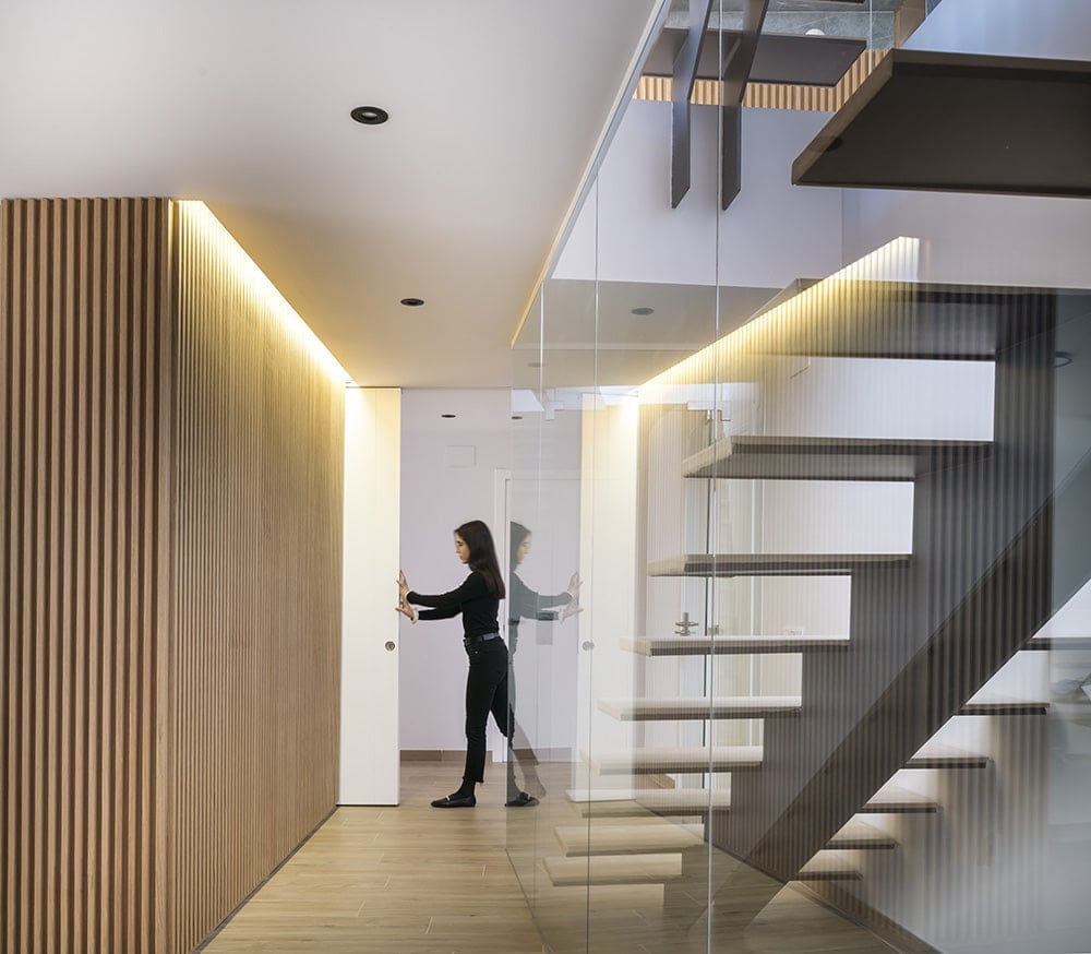 This hallway with a modern staircase is enclosed in a pocket door.