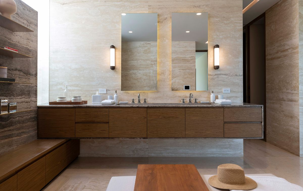 The bathroom vanity includes a floating counter with a marble undermount sink and lighting fixtures positioned on the wall with twin mirrors.