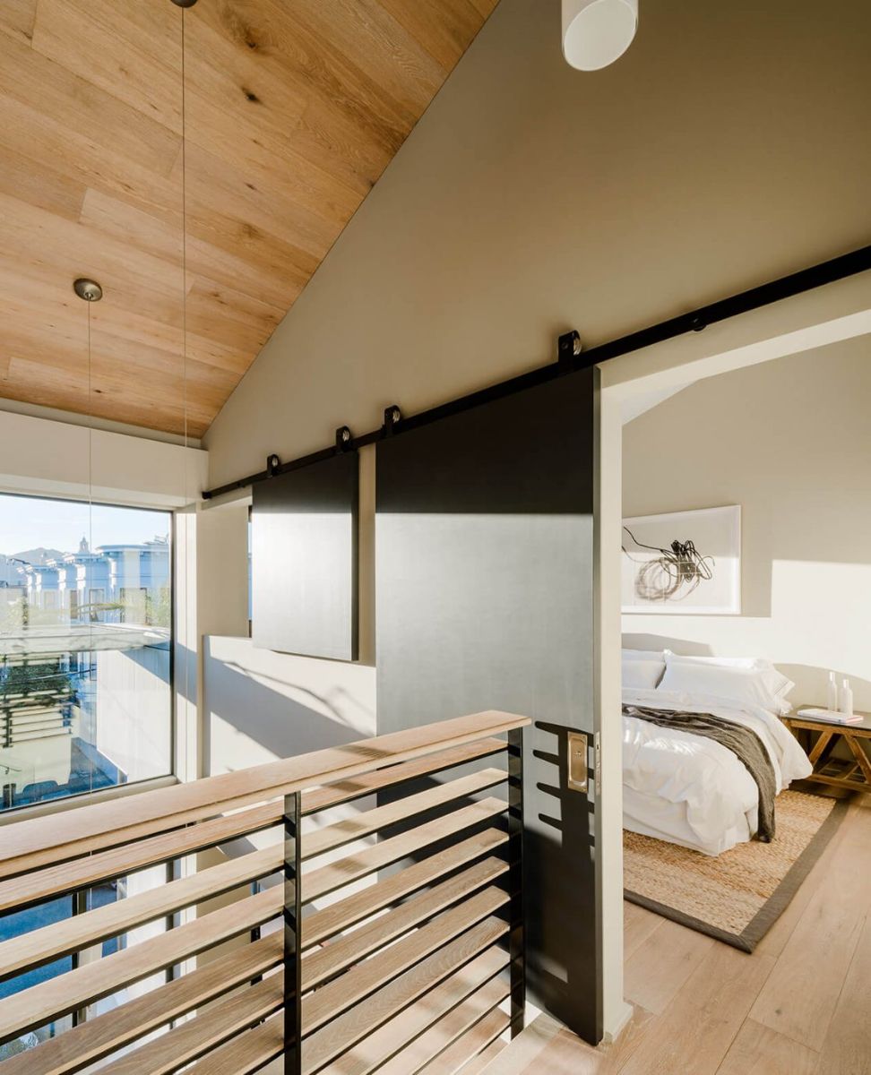 The bedrooms are on the second floor, with huge glass windows providing plenty of light and air, as well as a view of the adjacent houses.