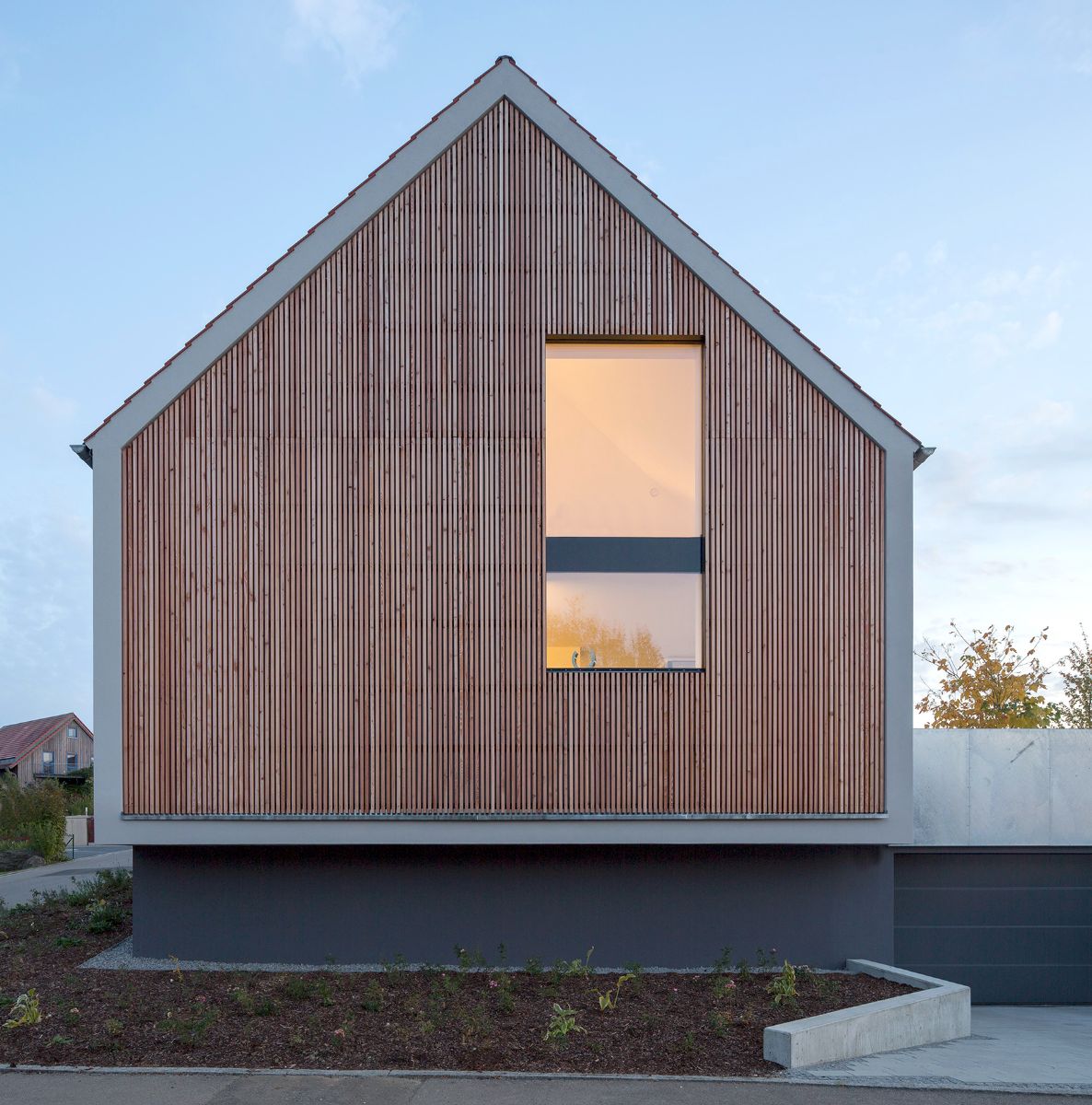 A front facade of the house built from mix of larch wood and hot-dip galvanized steel. The shaped from its silhouette, the "accessories" give the house its lightness.