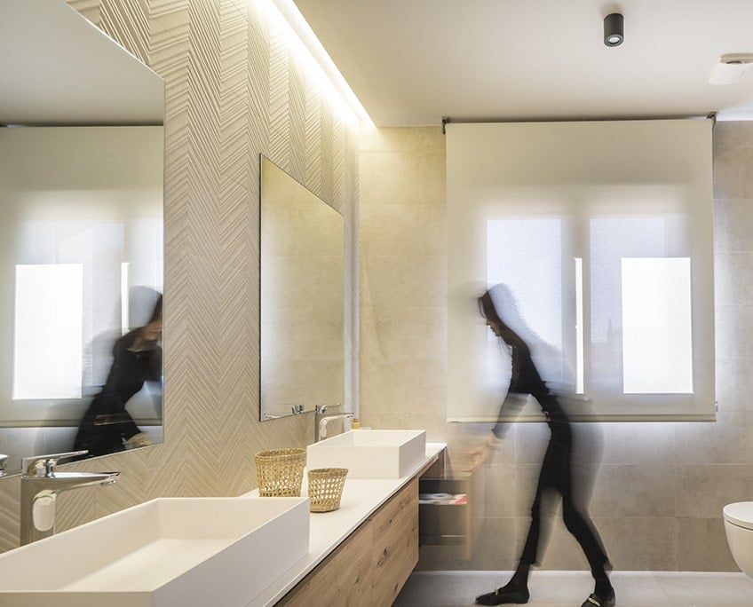 This bathroom features a large floating vanity equipped with two vessel sinks.