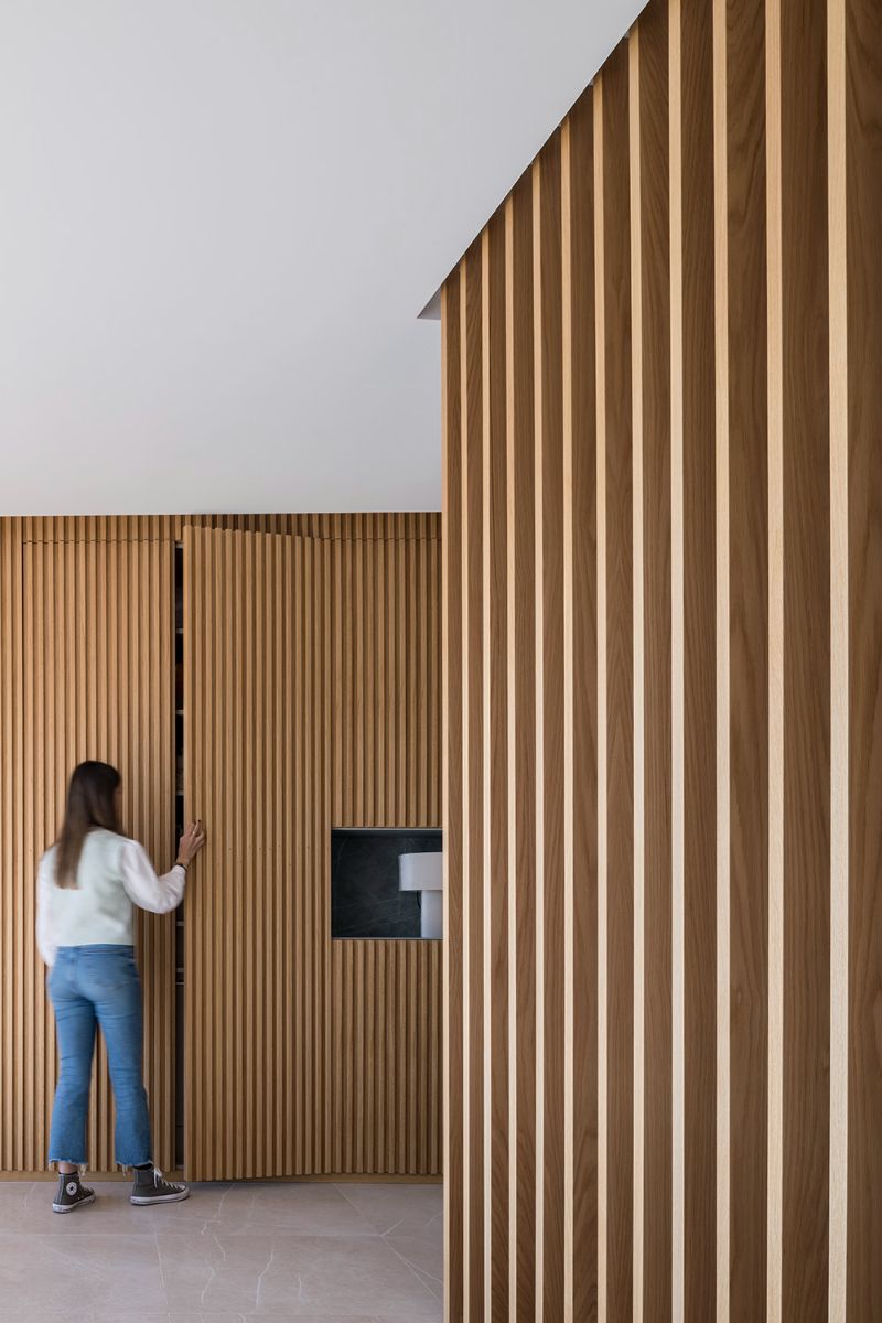 The wood slats conceal the built-in cabinets.