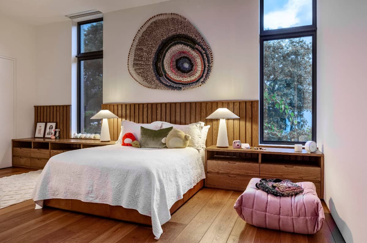 This bedroom is furnished with a Togo pouf by Michel Ducaroy and a woven artwork by Tammy Kanat.