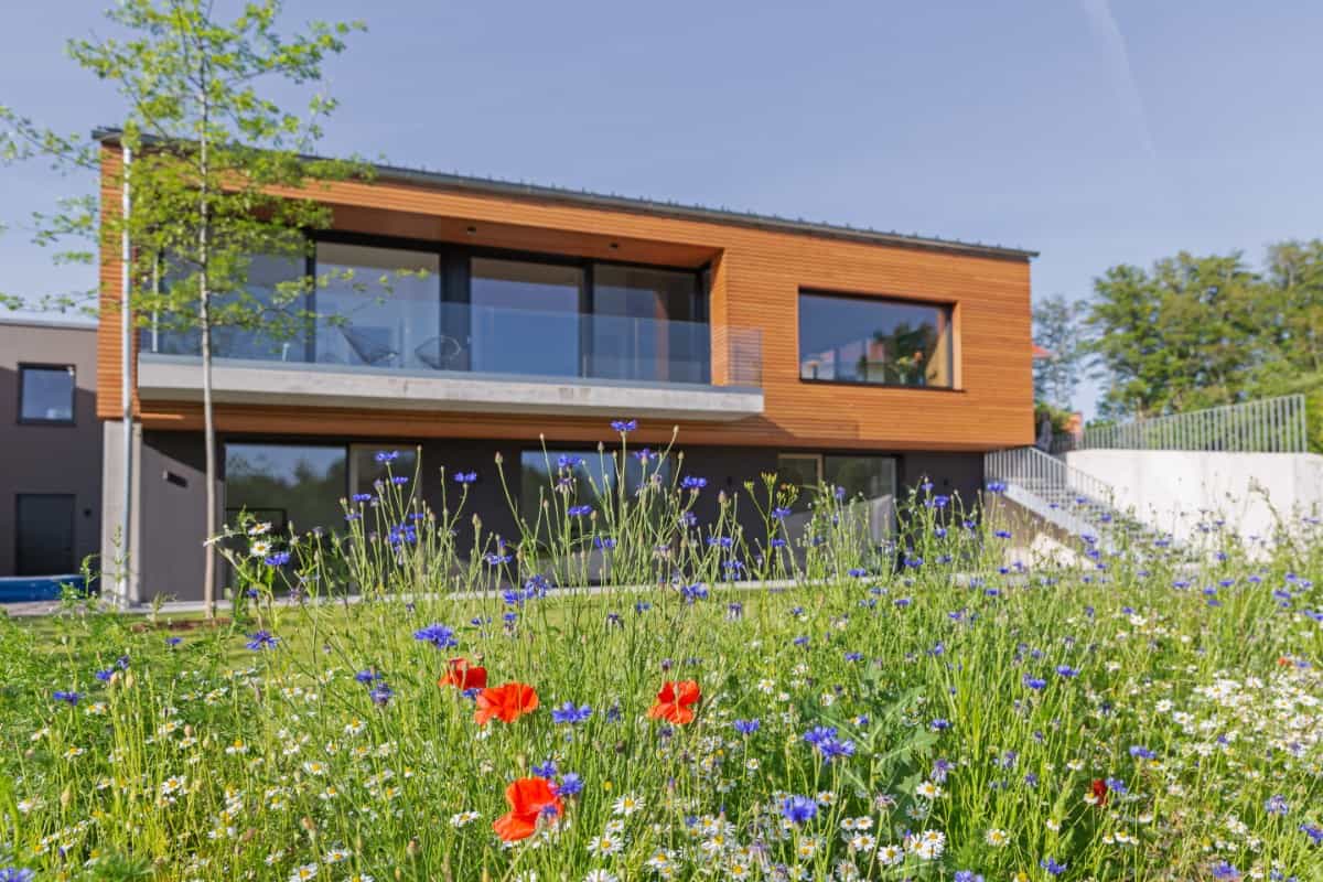 One last look at the home's faรงade with spacious outdoor living and an external staircase connecting the terrace to the garden.