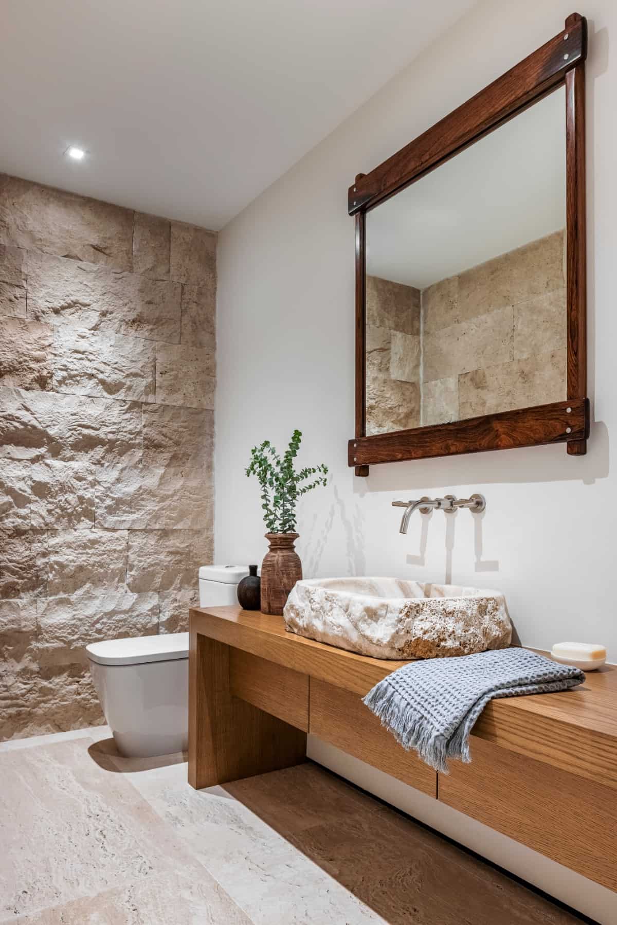 The wall and custom basin in the primary bathroom utilize the same Jersualem stone as the exterior.
