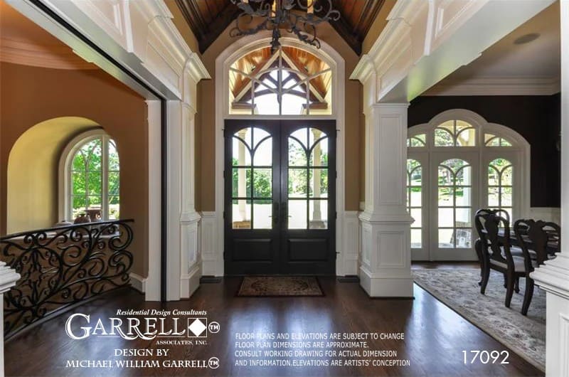 Foyer with a vaulted ceiling and a French entry door topped with an arched transom.