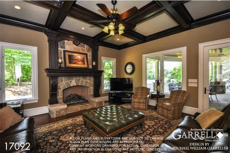 The keeping room features a coffered ceiling and a stone fireplace framed with dark, intricate wood trims.