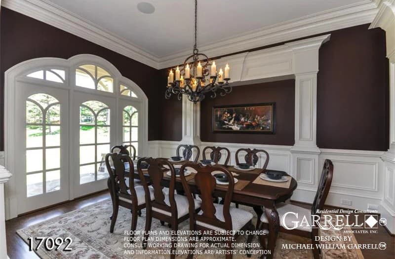 The formal dining room is decorated with arched windows, white wainscoting, and a large area rug.
