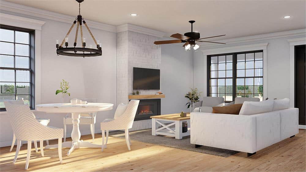The dining area has a wrought iron chandelier and a round dining table paired with matching chairs.