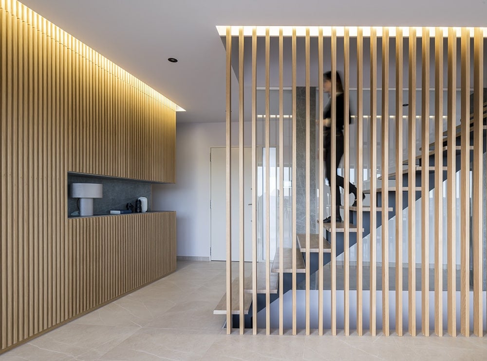 Wood slats clad the wall and provide security on the modern staircase.