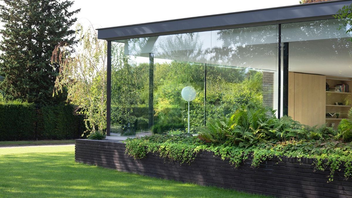 Right at the building's front are large integrated planters filled with vegetation.