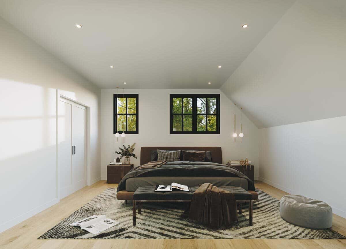 Primary bedroom with modern furnishings and a walk-in closet resting behind double white doors.