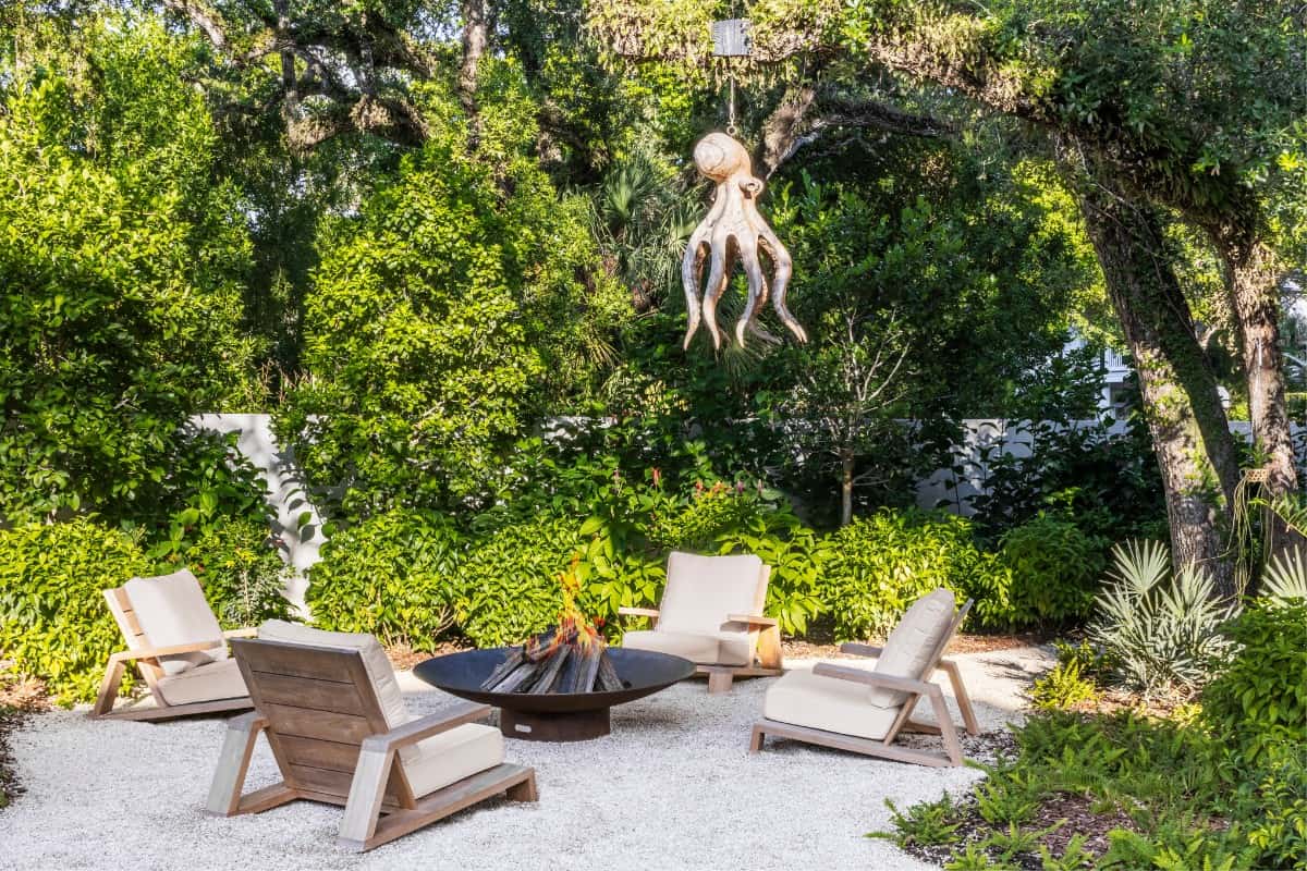 This outdoor seating area features a fire pit and evocative sculpture.
