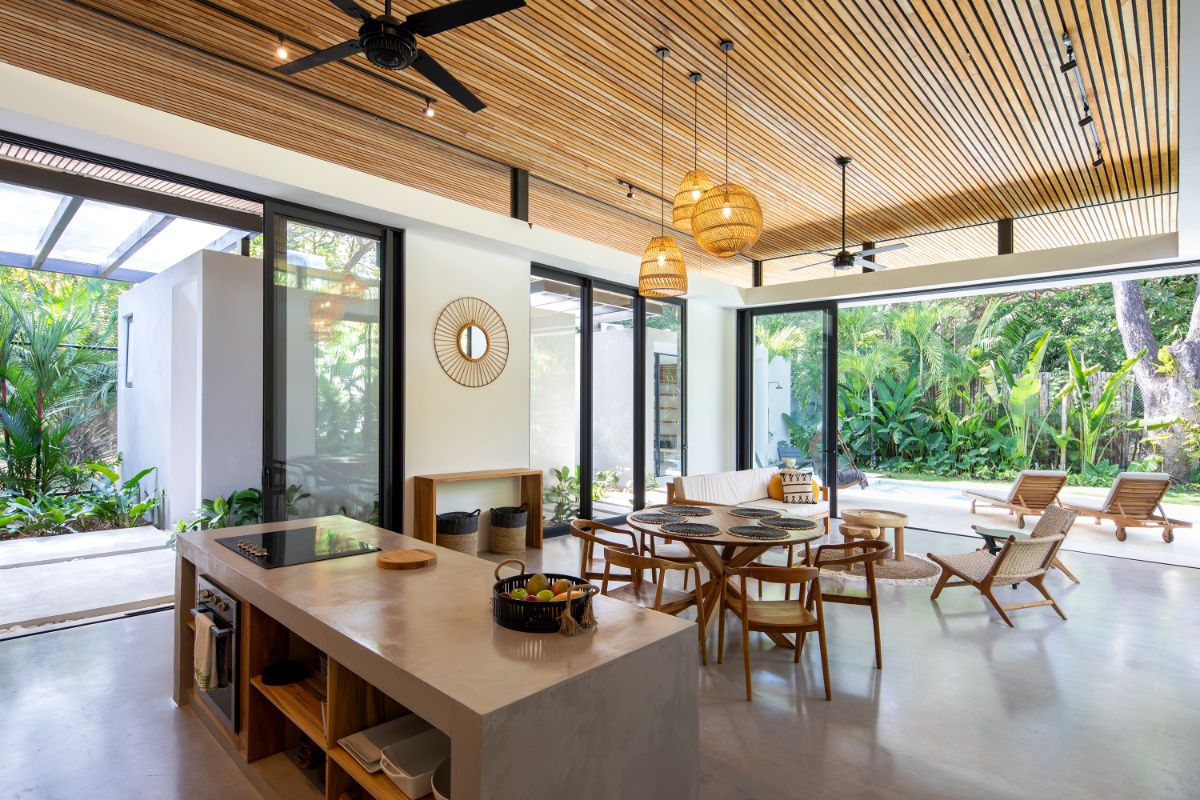 The primary living spaces are made out of light-weight steel frames that hold open spaces and welcome nature inside, as well as long steel rooflines coated in teak.