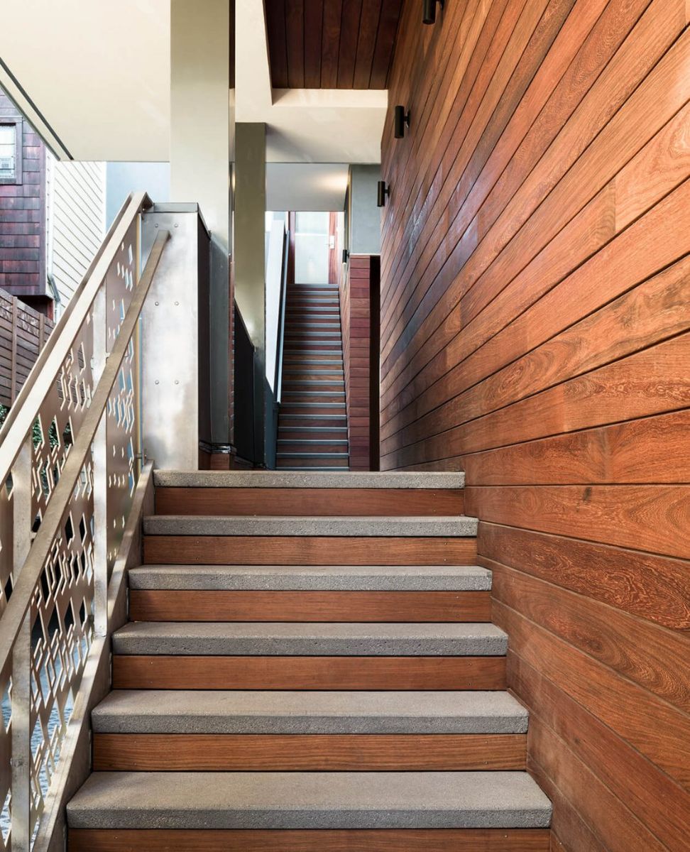 The stairs in the centre of the townhouse lead to the three units of the building and are composed of wood and concrete steps with steel railings.